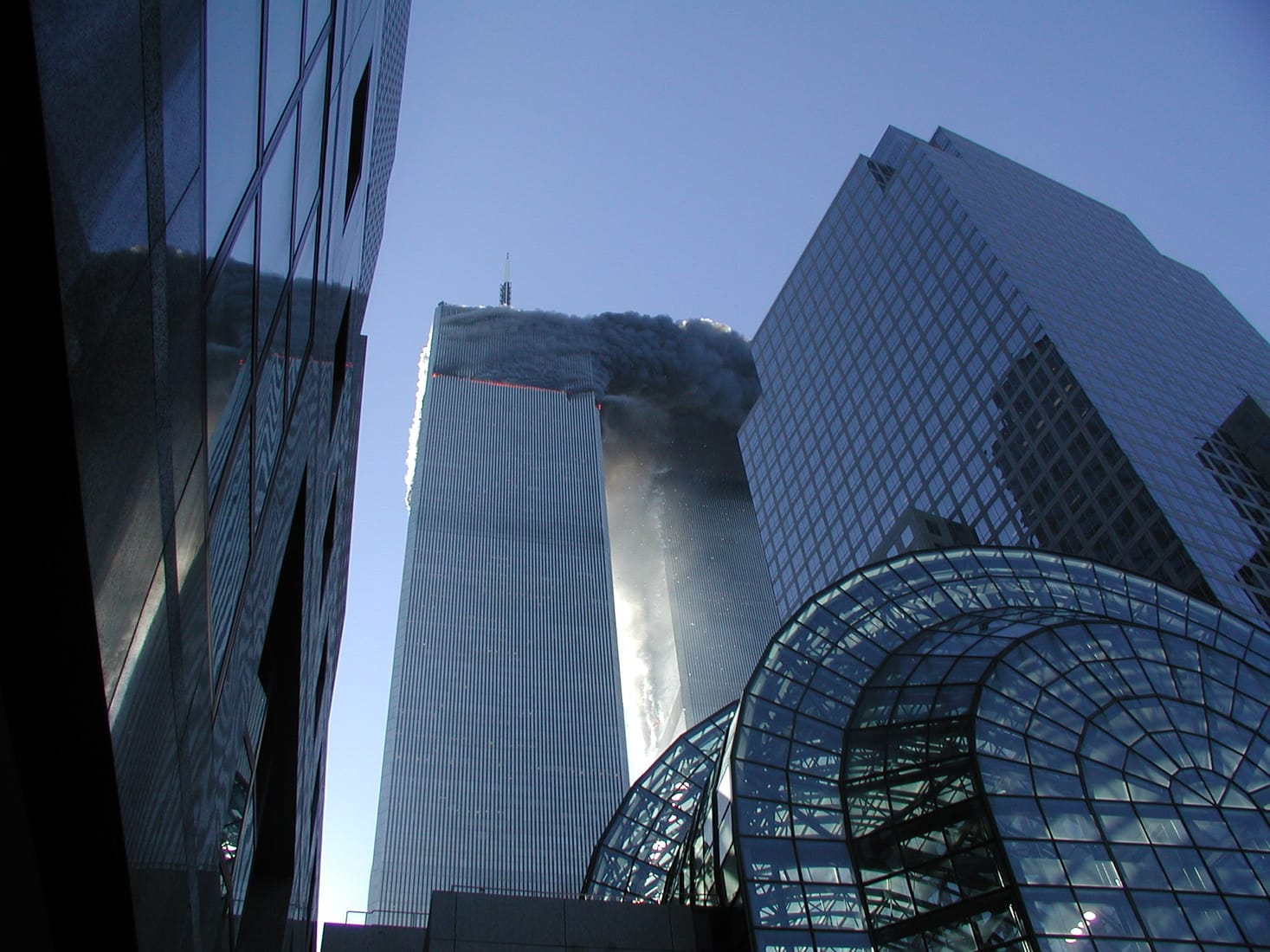 The smoking North Tower of the World Trade Center on September 11, 2001, seen across the water from Lower Manhattan’s waterfront.